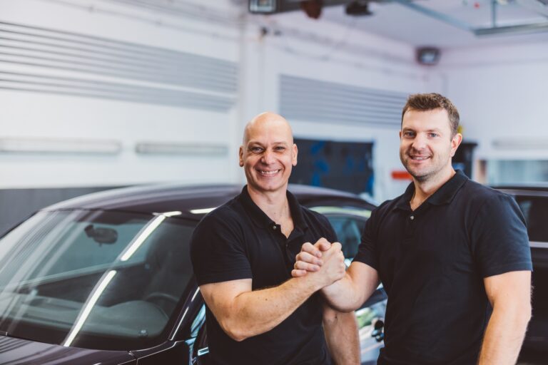Car mechanics team in car detailing workshop, teamwork partners